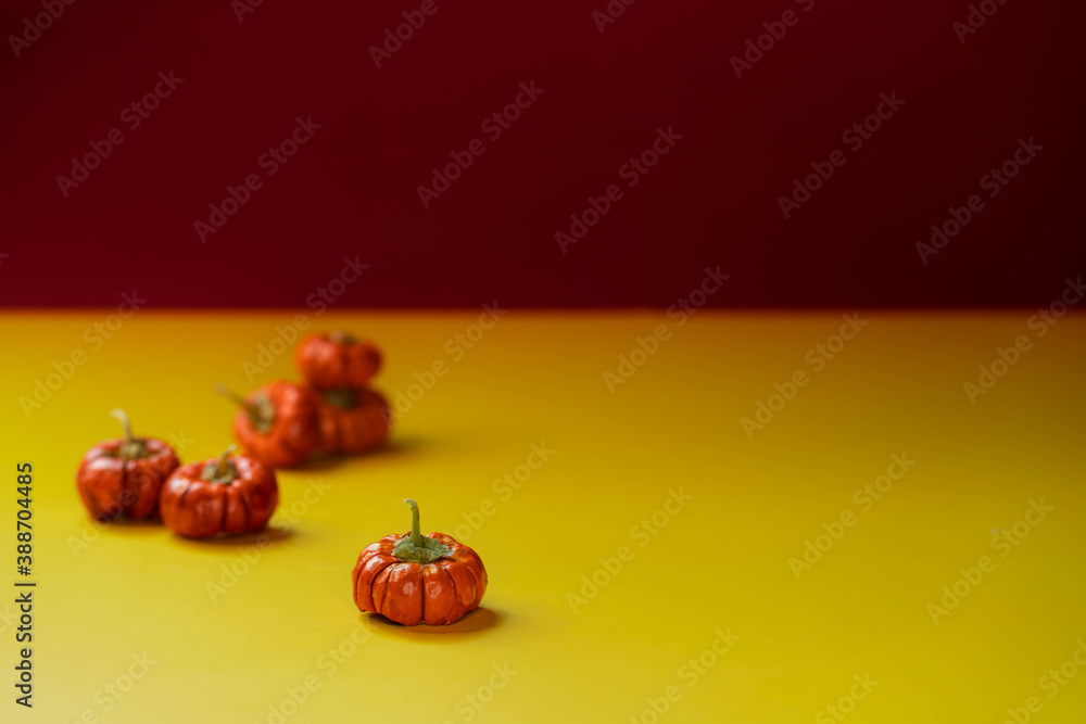 Group of little pumpkins over yellow surface