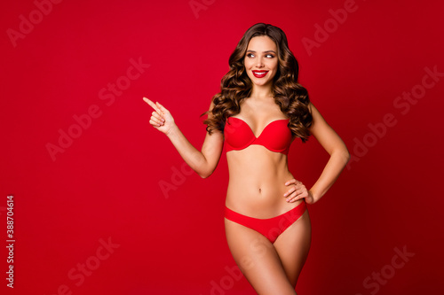 Photo of attractive beautiful curly lady model advertising underwear direct finger empty space sensual slim fit body wear brassiere panties isolated red color background