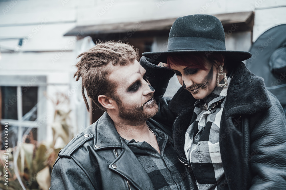 Scary love couple,man,woman.Family,mother,father celebrating halloween.Terrifying black skull face makeup. Witch costumes, stylish images.Horror,fun at children's party in barn on street.Hats,jackets Scary love couple,man,woman.Family,mother,father celebrating halloween.Terrifying black skull face makeup. Witch costumes, stylish images.Horror,fun at children's party in barn on street.Hats,jackets