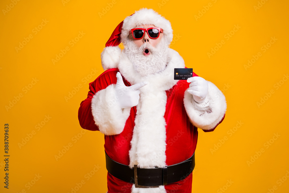 Portrait of his he nice attractive fat amazed astonished Santa holding in hand demonstrating bank card safe shopping novelty isolated bright vivid shine vibrant yellow color background Portrait of his he nice attractive fat amazed astonished Santa holding in hand demonstrating bank card safe shopping novelty isolated bright vivid shine vibrant yellow color background