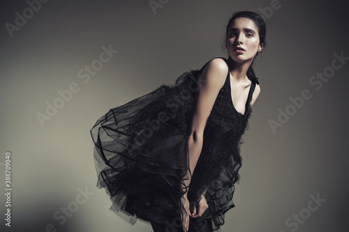 Sensual brunette woman in creative black fluffy dress