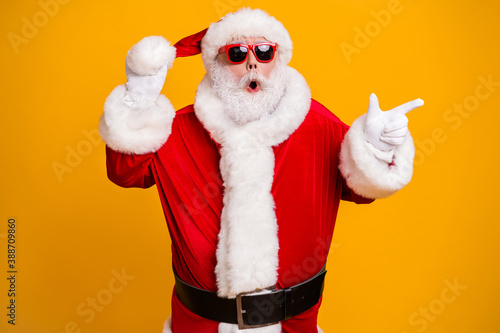 Portrait of his he nice attractive amazed tunned fat Santa demonstrating copy space choose choice shop offer advert ad isolated over bright vivid shine vibrant yellow color background