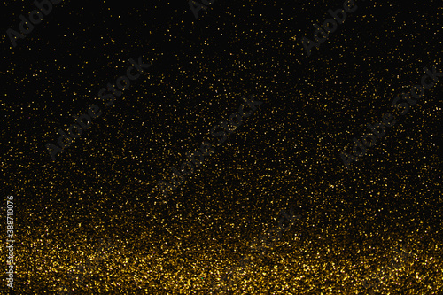 gold abstract pattern glitter stardust sparkling lights grunge on black.