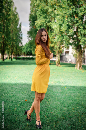 beautiful and slender girl in a yellow dress walking in the autumn park. walking concept. rest and beauty