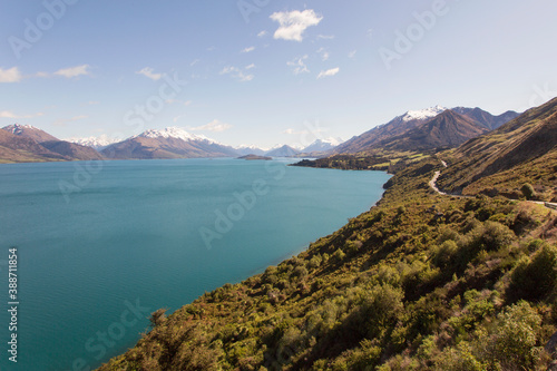 Road trip along the Glenorchy to Queenstown Road with views of snowcapped mountains and Lake Wakatipu - New Zealand South Island.