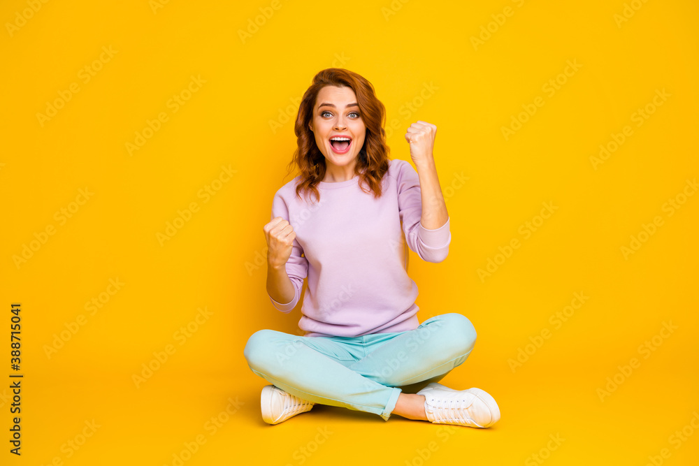 Full size photo of delighted cheerful woman sit legs crossed have win triumph raise fists scream yeah wear good look pullover isolated over bright color background Full size photo of delighted cheerful woman sit legs crossed have win triumph raise fists scream yeah wear good look pullover isolated over bright color background