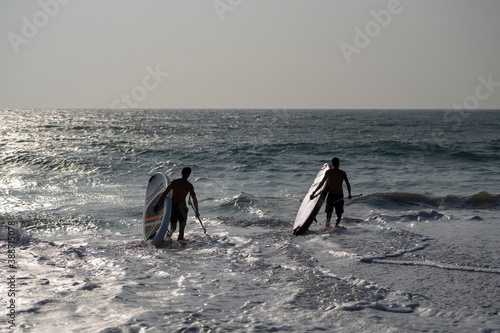 Attractive Men on Stand Up Paddle Board, SUP, Surfers breaking waves in the ocean. Sri Lanka
