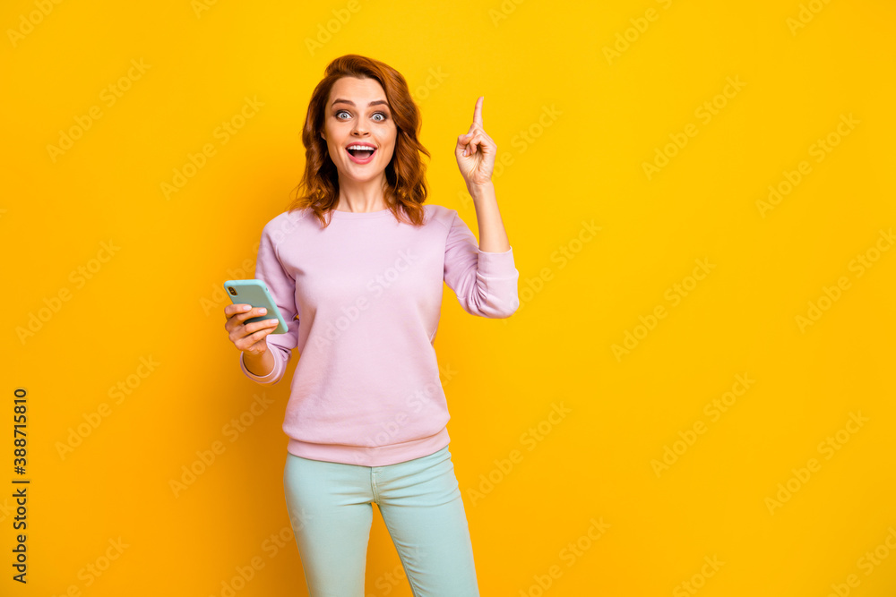 Excellent Photo of pretty lady hold telephone hands have creative post idea raise finger intelligent person wear pink pullover green pants isolated yellow color background Excellent Photo of pretty lady hold telephone hands have creative post idea raise finger intelligent person wear pink pullover green pants isolated yellow color background