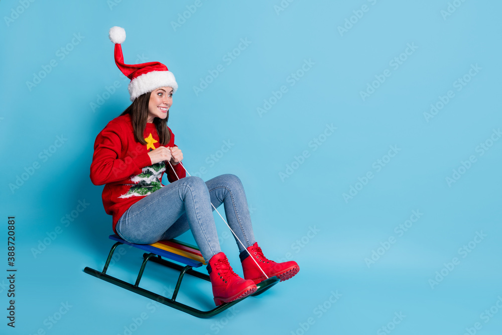 Obraz premium Photo portrait of woman riding sled into blank space isolated on pastel light blue background