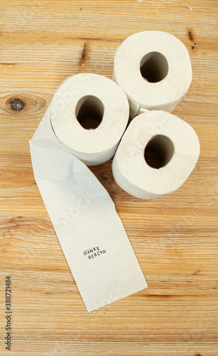 Toilettenpapier auf Holztisch mit Statement auf deutsch zu Berliner Entscheidung Entschluss