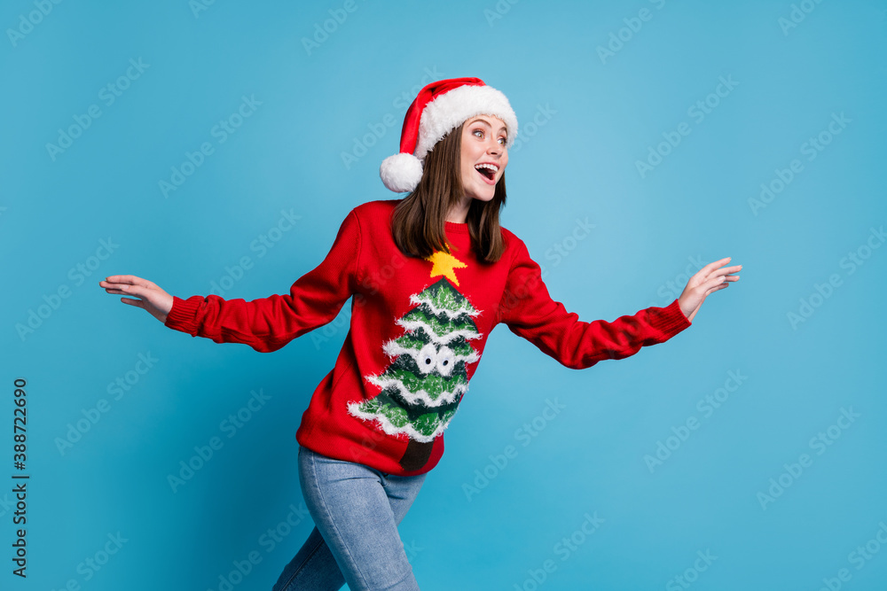 Photo of lovely pretty lady amazed look empty space raise hands running open mouth shocked wear santa x-mas headwear red ornamented sweater jeans isolated blue color background Photo of lovely pretty lady amazed look empty space raise hands running open mouth shocked wear santa x-mas headwear red ornamented sweater jeans isolated blue color background