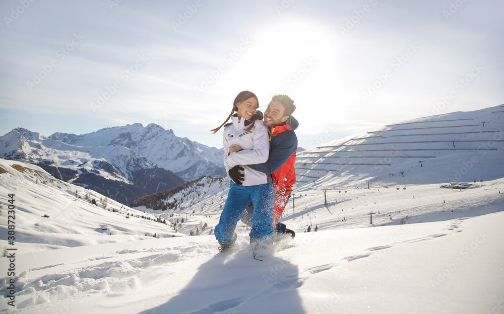 Beautiful couple playing in the snow on the top of the mountain