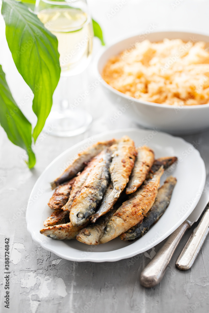 fried small sardines with tomato rice on white dish on ceramic fried small sardines with tomato rice on white dish on ceramic