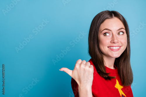 Close up photo of jolly holly girl point thumb finger copyspace indicate x-mas newyear ads wear red comfort pullover isolated over blue color background