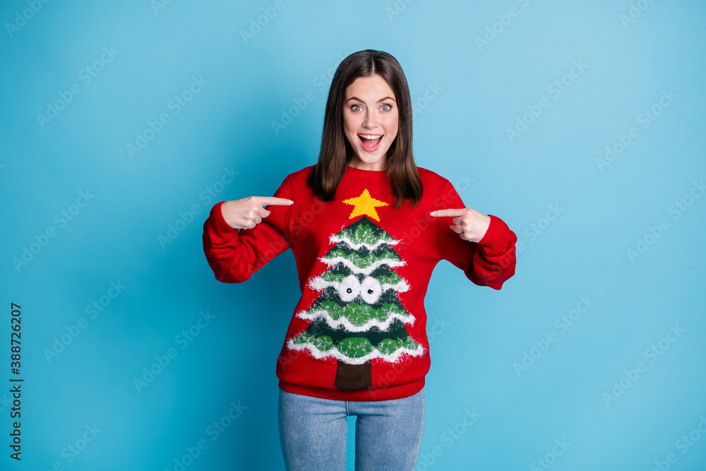 Photo portrait joyful brunette girl pointing fingers at herself surprised shocked smiling wearing red pullover with christmas tree googly eyes star isolated on pastel light blue colored background Photo portrait joyful brunette girl pointing fingers at herself surprised shocked smiling wearing red pullover with christmas tree googly eyes star isolated on pastel light blue colored background