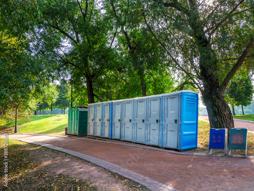 Portable washrooms in nature. Long row of portable bio toilet cabins in Moscow park. Line of chemical toilets for the holiday, festival. © sablinstanislav