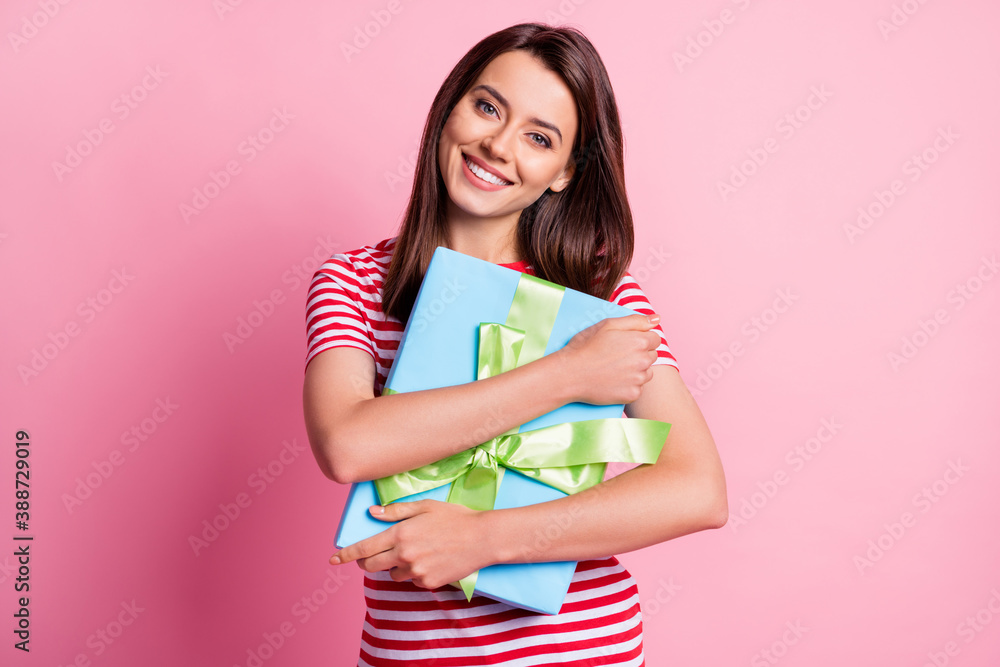 Photo portrait of happy cheerful birhtday girl hugging embracing wrapped gift smiling isolated on pastel pink color background Photo portrait of happy cheerful birhtday girl hugging embracing wrapped gift smiling isolated on pastel pink color background