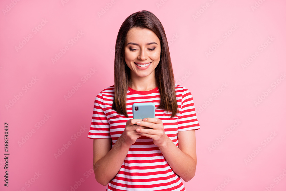 Photo of pretty fun young lady looking telephone wear stripy red white t-shirt isolated over pink background Photo of pretty fun young lady looking telephone wear stripy red white t-shirt isolated over pink background