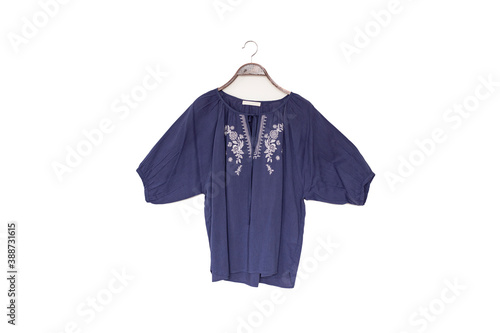 Blue colour blouse is clothes hanger on white background.