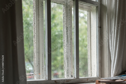 old wooden white frame of large village window in morning