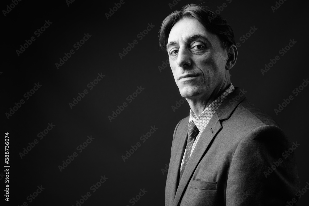 Mature handsome Italian businessman against gray background Mature handsome Italian businessman against gray background