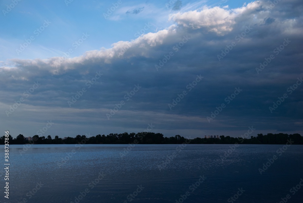 Dark blue clouds and blue sky, river, sunlight and sunshine , sun rays through clouds Dark blue clouds and blue sky, river, sunlight and sunshine , sun rays through clouds