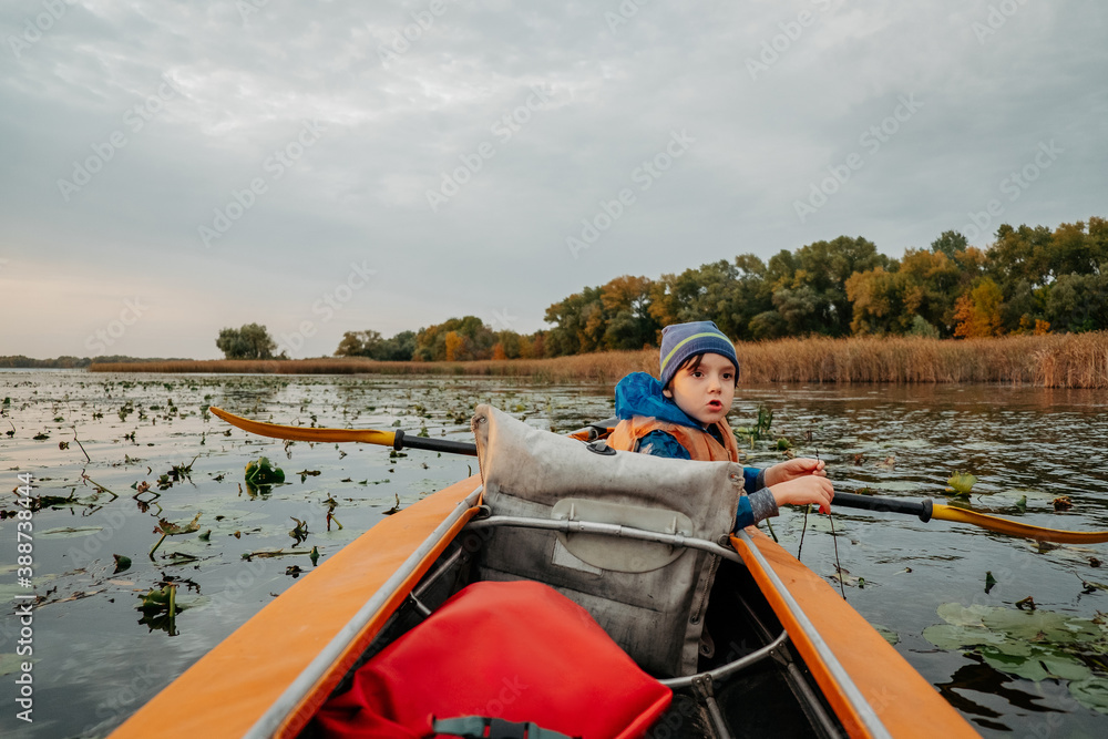 Evening kayak trip along the river in autumn. The active lifestyle of the child in the family. Evening kayak trip along the river in autumn. The active lifestyle of the child in the family.