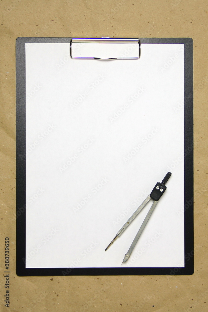 A tablet with a white sheet of A4 format on a beige craft paper. A tablet with a white sheet of A4 format on a beige craft paper.