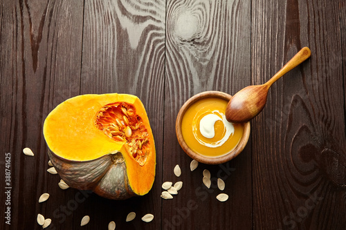 Autunm flat lay with pumpkin soup in bowl and fresh pumpkins photo