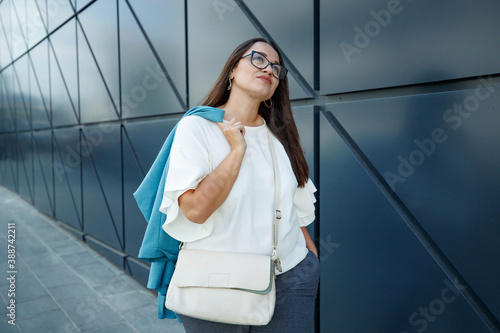 Young fat stylish woman on a city street. Spring fashion outfit, elegant look. Plus size model. High quality photo.