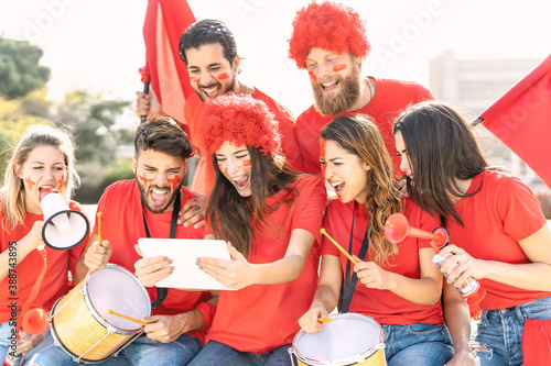 Foto Friends football fans watching soccer match event on mobile digital tablet - You