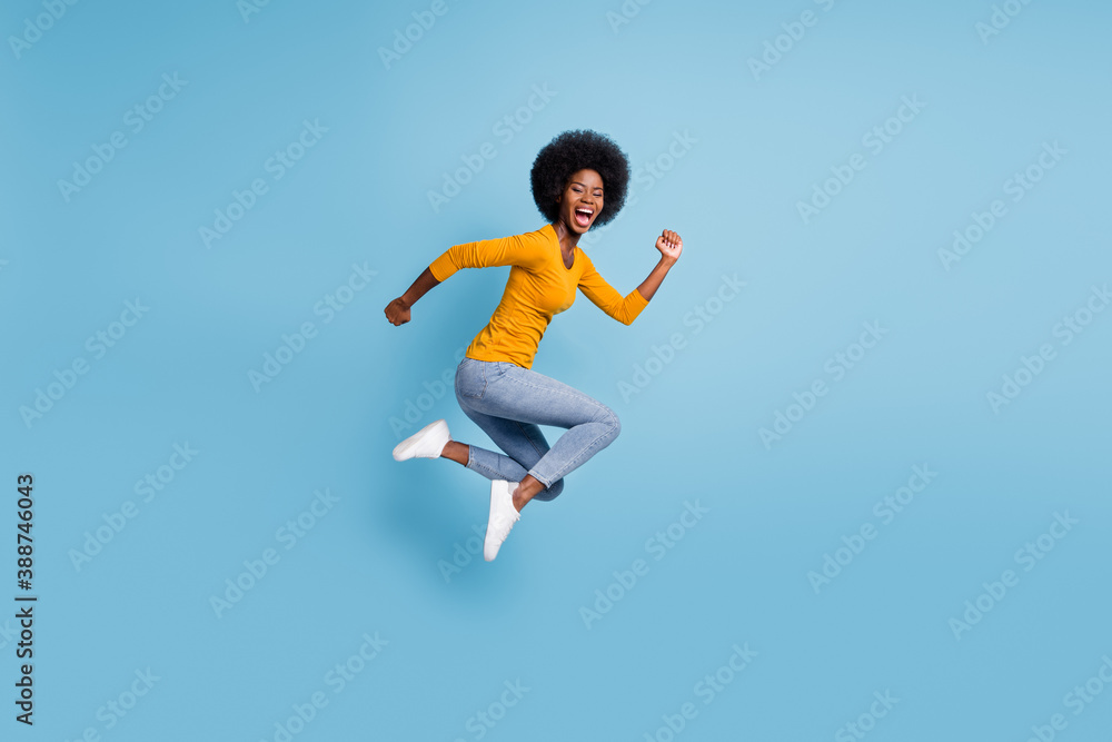 Photo portrait full size of woman running jumping up isolated on pastel blue colored background