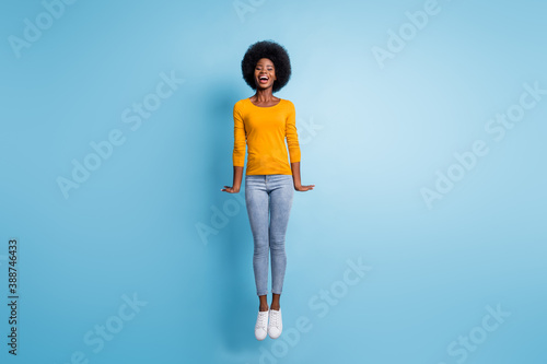 Photo portrait full body of woman jumping straight up isolated on pastel blue colored background