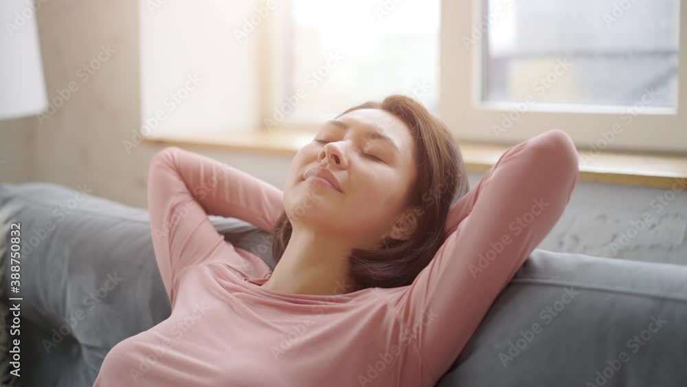 Attractive young asian woman resting on cozy sofa taking deep breath of fresh air holding hands behind head, happy calm mixed race lady relaxing and dreaming on comfortable couch feel stress free Attractive young asian woman resting on cozy sofa taking deep breath of fresh air holding hands behind head, happy calm mixed race lady relaxing and dreaming on comfortable couch feel stress free