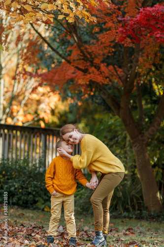 A beautiful young mother and her son are walking in the autumn park. A happy family.