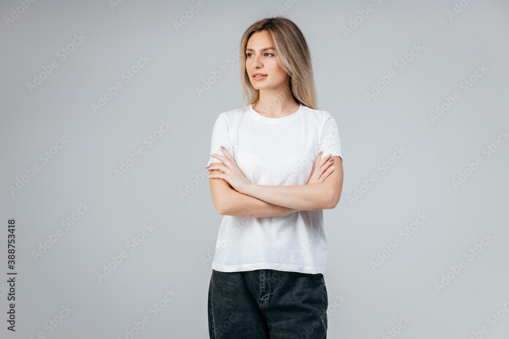 Stylish blonde girl wearing white t-shirt posing in studio Stylish blonde girl wearing white t-shirt posing in studio