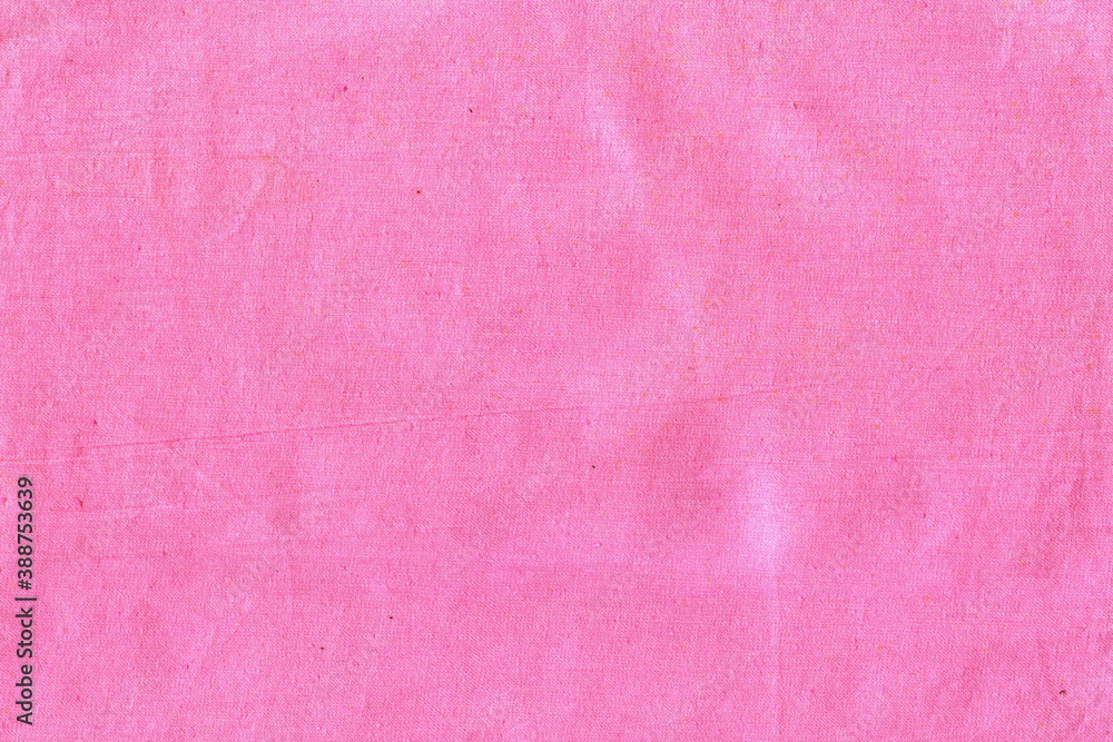 The texture of natural cotton fabric is pink. The background is a simple fabric, not very smooth, crumpled. The texture of natural cotton fabric is pink. The background is a simple fabric, not very smooth, crumpled.