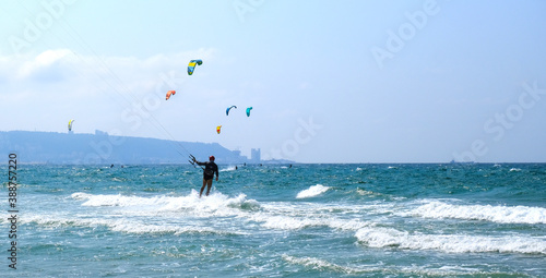 Sunny summer beach with people engaged in kitesurfing. Israel. Kiryat Yam. Haifa