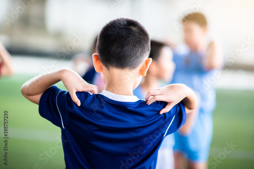 Selective focus to Soccer player is standing and catch the shoulder to warming up and stretching the body before the competition or practicing.