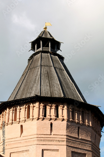 Red brick tower and wooden roof against the sky.