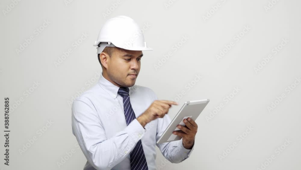 Asian civil engineer operate with tablet to control working at studio office. Worker wearing hard hat standing on isolated white background. 4k resolution. Asian civil engineer operate with tablet to control working at studio office. Worker wearing hard hat standing on isolated white background. 4k resolution.