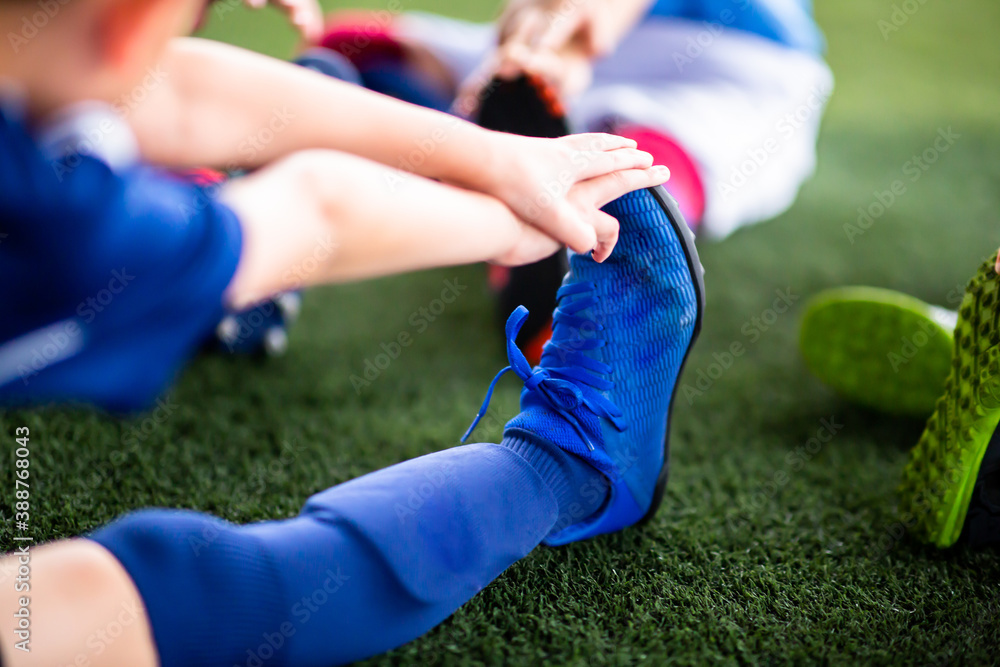 Selective focus to Kid soccer players are stretching their hands to catch their feet to warming up and stretching the body and foot Selective focus to Kid soccer players are stretching their hands to catch their feet to warming up and stretching the body and foot