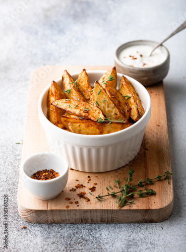 baked potato wedges with sauce on a light background