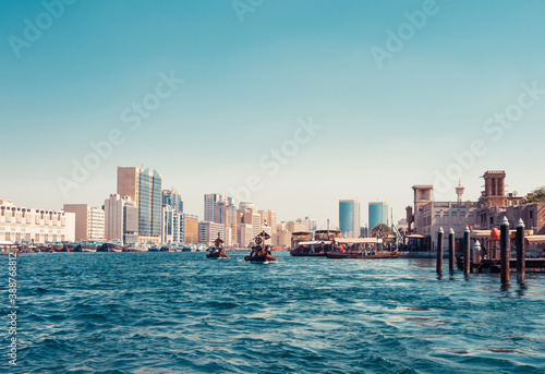 Photography Skyline view of Dubai Creek with traditional boats and piers