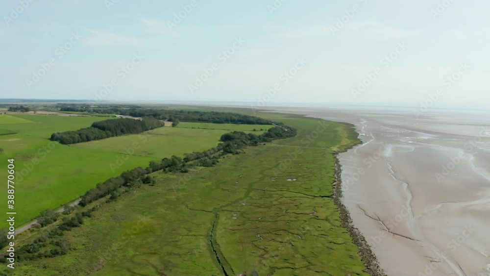 Aerial Landscape View of a Skyline over a Vast Grassland alongside the Wet Sand Aerial Landscape View of a Skyline over a Vast Grassland alongside the Wet Sand