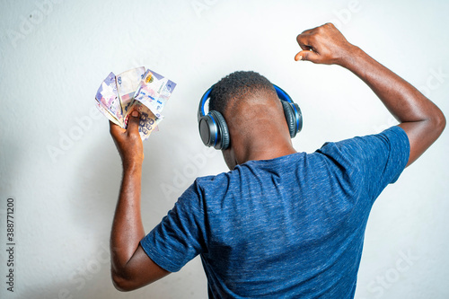 back image of african guy with bank note, head phone- ghana cedis notes photo