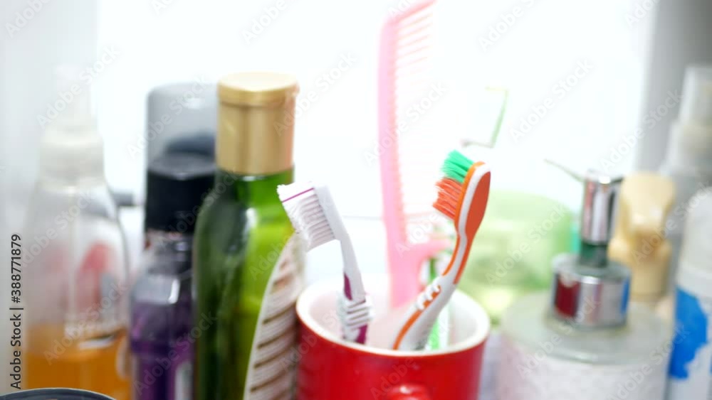 A Hand Protected by Glove Opens the Bathroom Cabinet Drawer and Takes a Toothbrush A Hand Protected by Glove Opens the Bathroom Cabinet Drawer and Takes a Toothbrush
