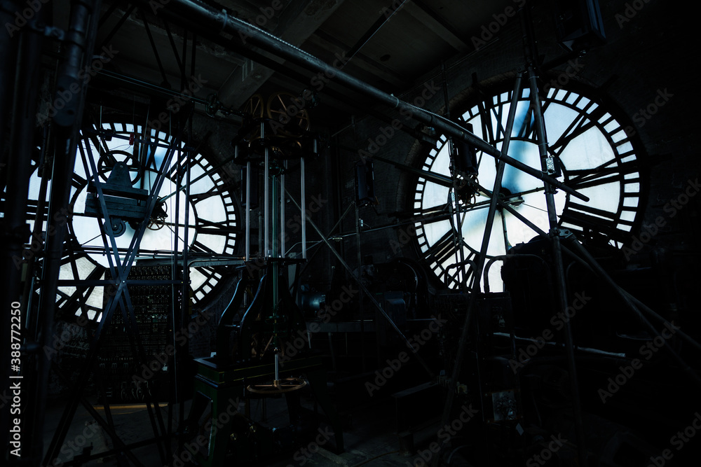 Interior of old big tower clock face mechanism inside brick space with two sides of the building