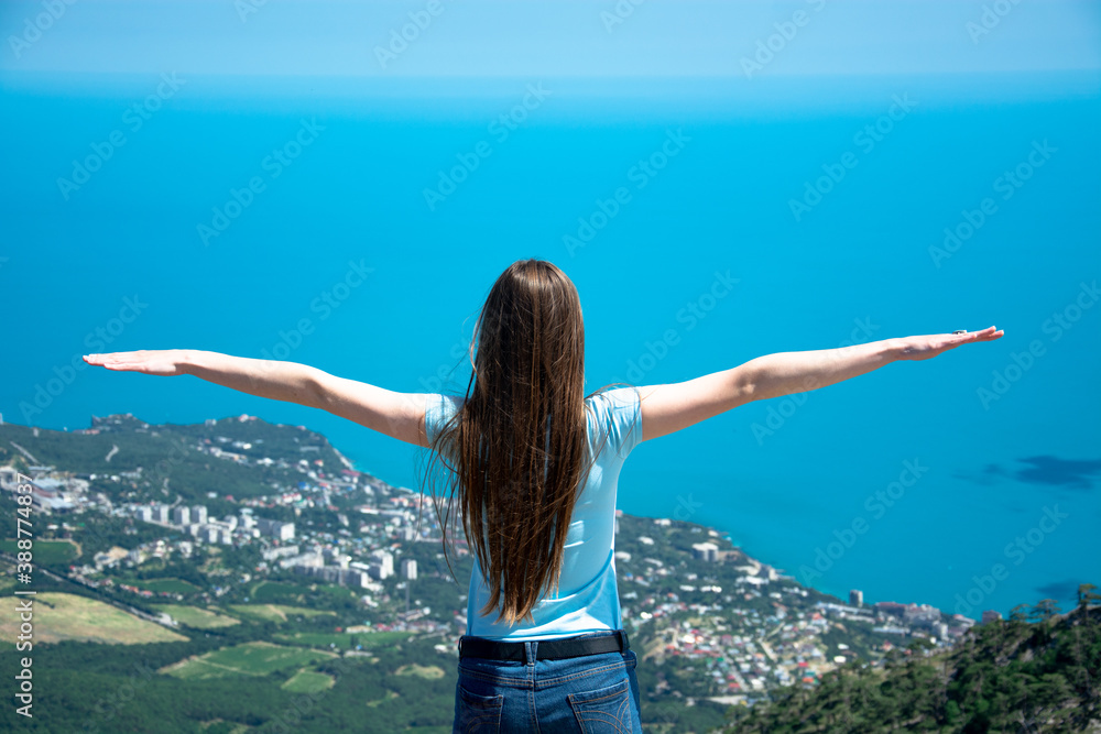 Happy woman standing on a mountain with her arms up in the air feeling happy and free. Happy woman standing on a mountain with her arms up in the air feeling happy and free.