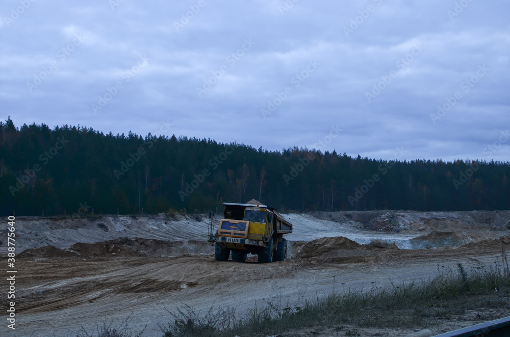 Heavy mining truck driving through the iron ore opencast Heavy mining truck driving through the iron ore opencast
